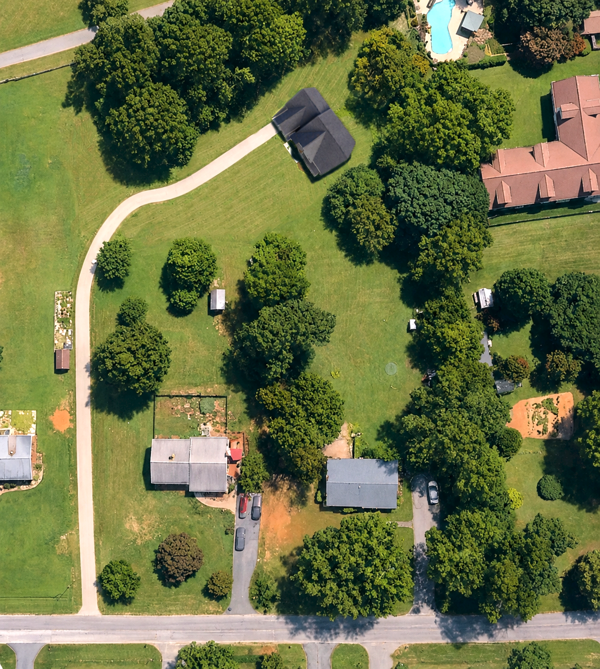 Finished rendering of Lot 75 with the new home, curved driveway, grading, and preserved tree line in place