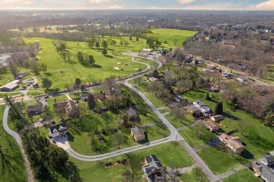 Unmarked aerial view of the neighborhood and golf course surrounding the parcel